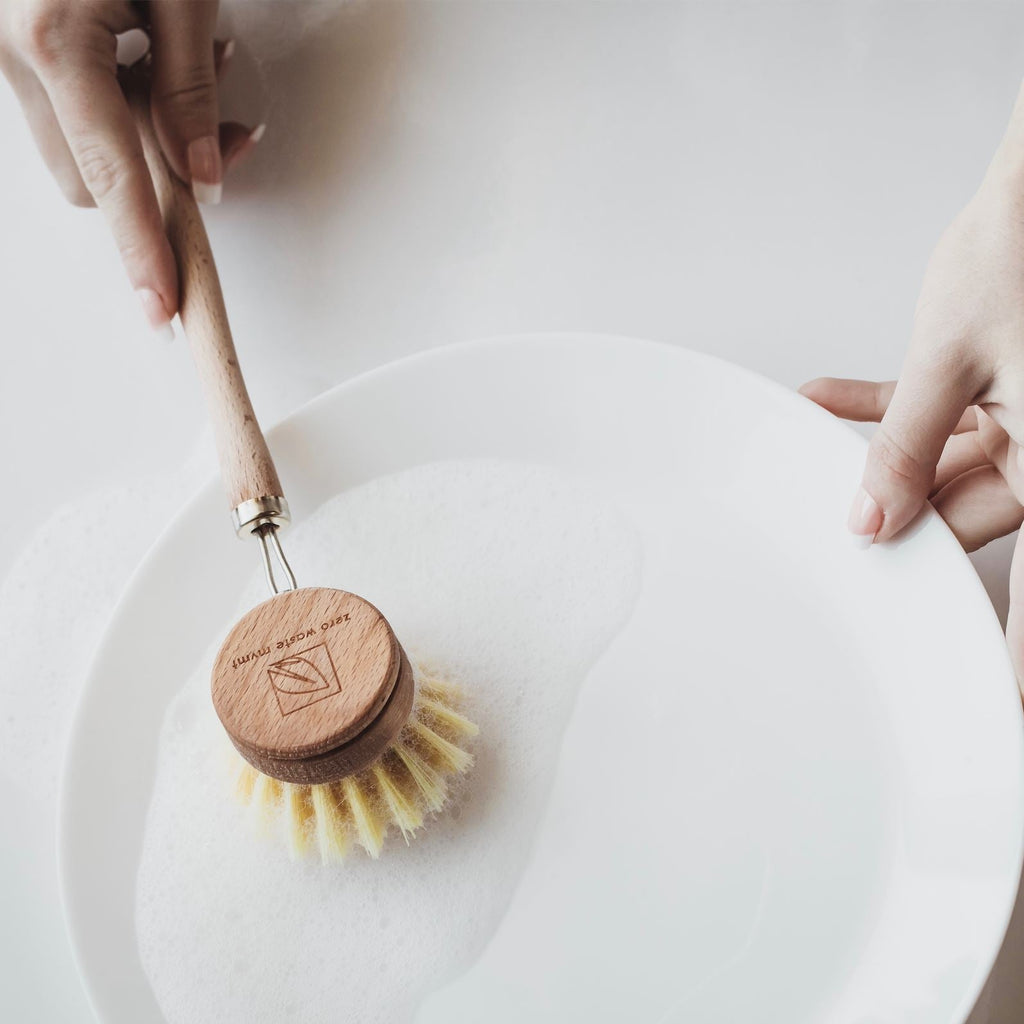 Washing a plate with the wooden dish brush